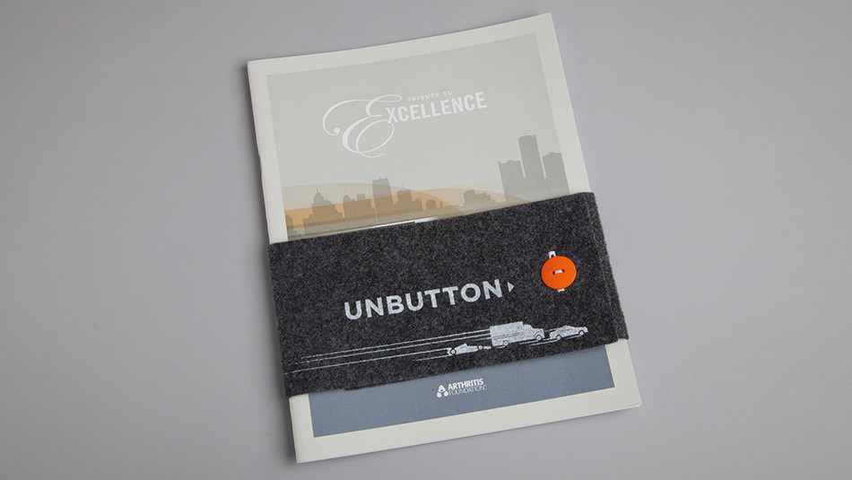 A booklet with some cloth wrapped around it fastened with a button